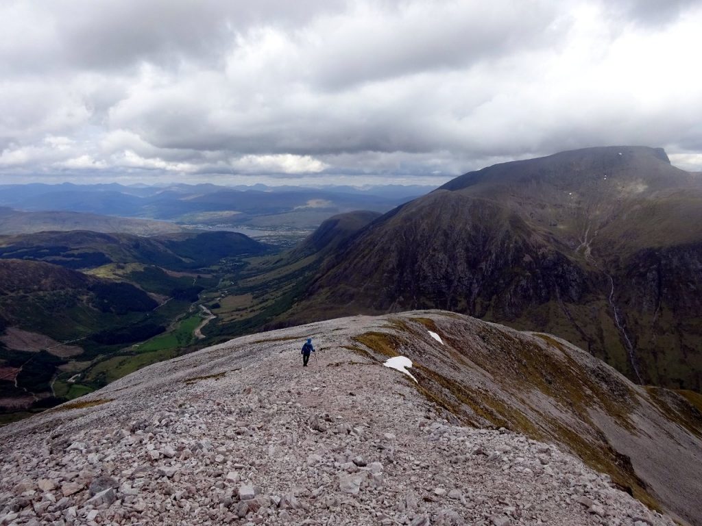 Descending the apron of shattered granite on top of Sgurr a Mhaim, with Ben Nevis across the valley of Glen Nevis